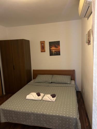 a bedroom with a bed with two towels on it at Rooms & Apartments Semić in Opatija