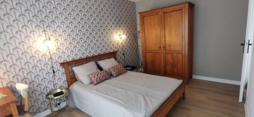 une chambre avec un lit et une armoire en bois dans l'établissement Chez Brigitte,, à Pornichet