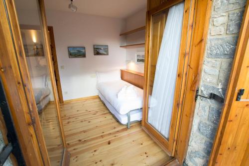 アルプにあるCasa amb jardí Alpのベッドと窓が備わる小さな客室です。