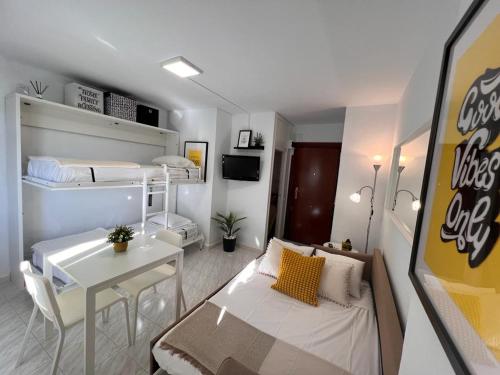um pequeno apartamento com uma cama e uma sala de jantar em Estudio con piscina a 200 m de la playa em Benalmadena Costa