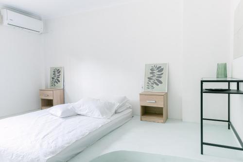 um quarto branco com uma cama e duas mesas de cabeceira em Rodini House em Kato Rodini