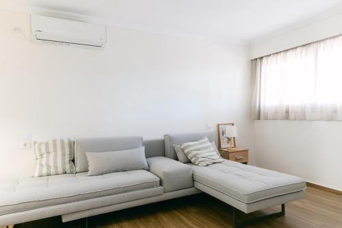 a white living room with a couch and a window at Rodini House in Kato Rodini