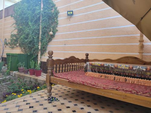 a wooden bench sitting in front of a wall at Imran&Bek in Samarkand