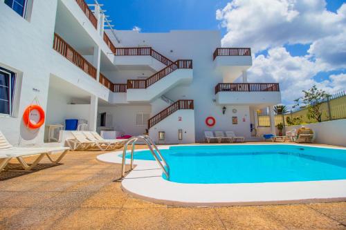 a pool in front of a building with stairs at Vista Mar Apartamentos in Puerto del Carmen