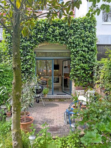 an entrance to a garden with plants and chairs at Mediterrane EG-Wohnung / BASF-Nähe / 650mbit WLAN in Ludwigshafen am Rhein