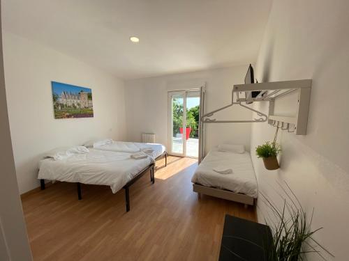 ein Schlafzimmer mit zwei Betten und einem Fenster in der Unterkunft Appartement 10pers. à Vallères in Vallères