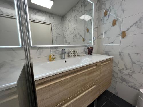 a bathroom with a sink and a mirror at Le Richelieu in Courbevoie