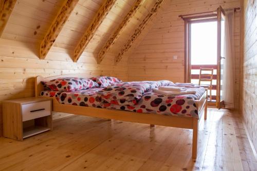 Ce lit se trouve dans une chambre en bois dotée d'une fenêtre. dans l'établissement D&S Kovacevic Apartments Zabljak, à Žabljak