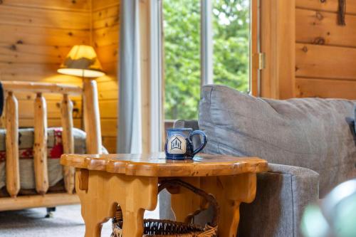 a coffee table with a mug on it next to a chair at Three Bear Lodge in Ridgedale