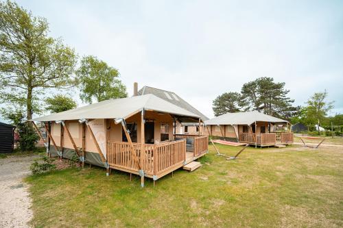 a group of cottages in a field at Glamping Callantsoog in Callantsoog