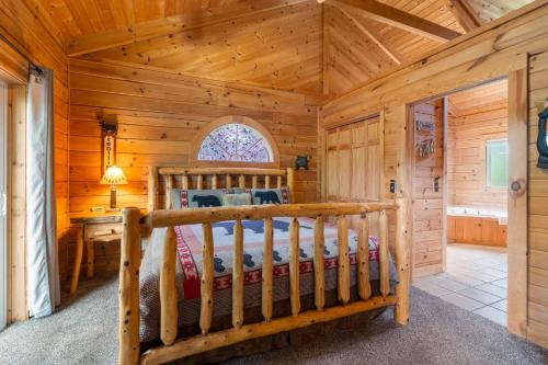 a log cabin bedroom with a bed and a desk at Three Bear Lodge in Ridgedale