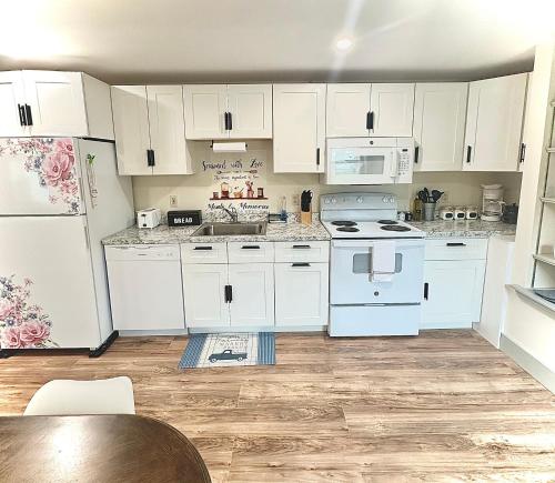 a kitchen with white appliances and a wooden floor at 2BR Sunshine Town Condo in Newport