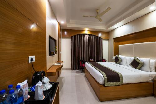 a hotel room with a bed and a desk with a table sidx sidx at HOTEL ANAND INTERNATIONAL in Bodh Gaya