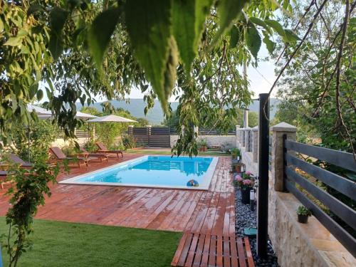 a backyard with a swimming pool and a wooden deck at Apartment Karla SNB in Lozovac