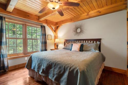 Un dormitorio con una cama con ventilador de techo. en Persimmon Hollow with GameRoom, en Blue Eye