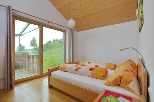 sypialnia z łóżkiem i dużym oknem w obiekcie Ferienhof Feurle w mieście Sulzberg