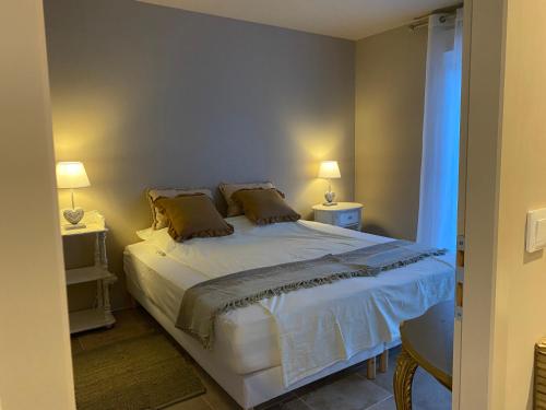 - une chambre avec un grand lit et deux lampes dans l'établissement L'Eveil en Provence, à Entrecasteaux