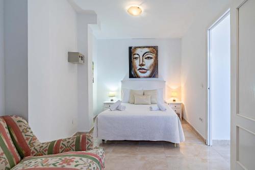 a bedroom with a bed with a painting on the wall at Apartamentos Dulcemar Frente al Mar con zona SPA in San José