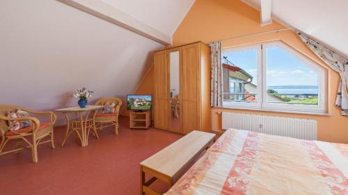 哈格瑙的住宿－Sonnenhof Hagnau，一间卧室配有一张床、一张桌子和一个窗户。