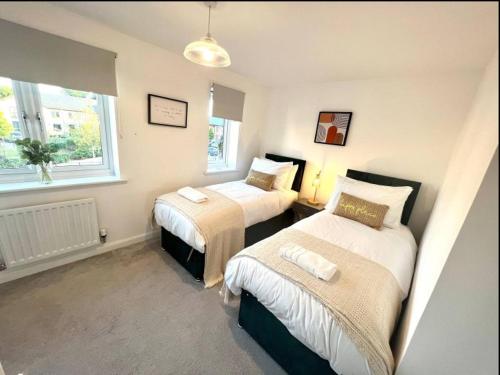 a bedroom with two beds and a window at Broad Acre House - Nr Racecourse in Cheltenham