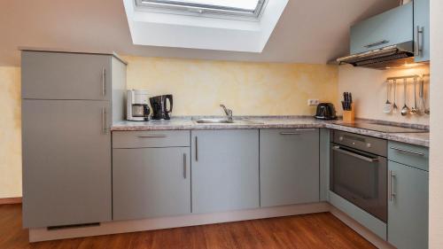 a kitchen with white cabinets and a sink at Sonnenhof Hagnau in Hagnau