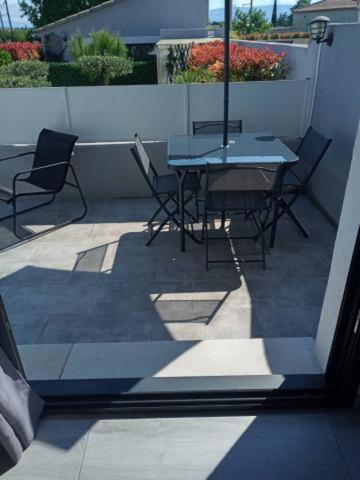 a patio with a table and chairs on a balcony at VILLA NOUNOU in Le Thor