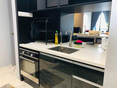 a kitchen with a sink and a stove top oven at Lumi Tropicana (2 in 1) sleep up to 18 in Petaling Jaya