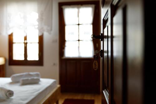 a room with a bed and a door with a window at Hotel Sarajet 1821 in Gjirokastër