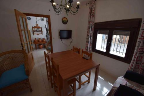 a dining room with a wooden table and a window at Apartamentos Horno y Casa De Dulce in Purullena