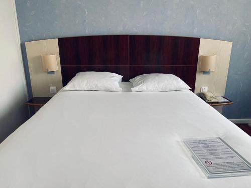 ブザンソンにあるMercure Besancon Parc Micaud - Hotel & Barの大きな白いベッド(枕2つ付)