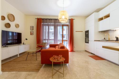 een woonkamer met een rode bank en een tv bij Sonnino House in Cagliari