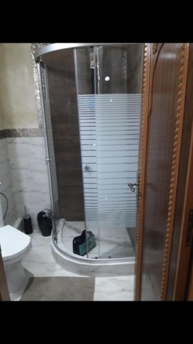 y baño con ducha y puerta de cristal. en Appartement avec piscine Mohamedia 2chambres, en Mohammedia