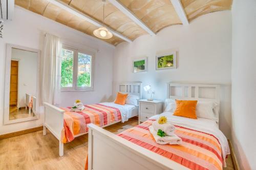 dwa łóżka w pokoju z dwoma oknami w obiekcie Ideal Property Mallorca - Sol de Mallorca 2 w Cala Mesquida