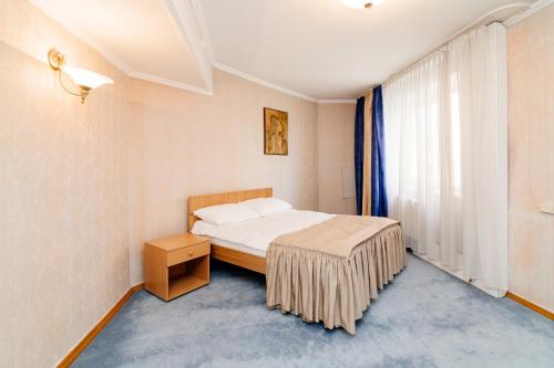 a hotel room with a bed and a window at Dacia Hotel in Chişinău