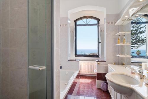 La salle de bains est pourvue d'une baignoire, d'un lavabo et d'une douche. dans l'établissement Capriccio, à Bordighera
