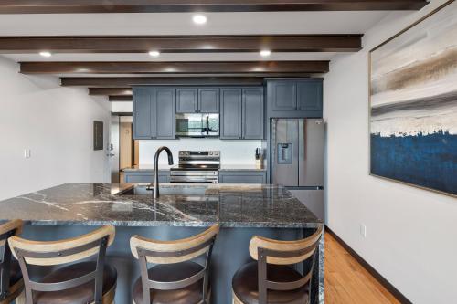 a kitchen with a large island with bar stools at McGregor & Main - Luxury Lofts in Hill City