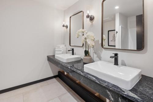a bathroom with two sinks and two mirrors at McGregor & Main - Luxury Lofts in Hill City