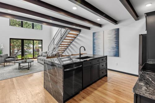 a kitchen with black appliances and a living room at McGregor & Main - Luxury Lofts in Hill City