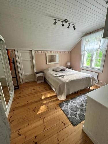 um quarto com uma cama e piso em madeira em Huvila Kyrönniemi em Savonlinna