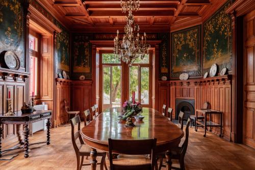 uma sala de jantar com uma mesa de madeira e um lustre em Chalet Ficalho em Cascais