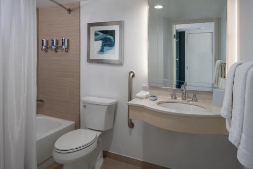a bathroom with a toilet and a sink and a tub at Four Points by Sheraton Suites Tampa Airport Westshore in Tampa