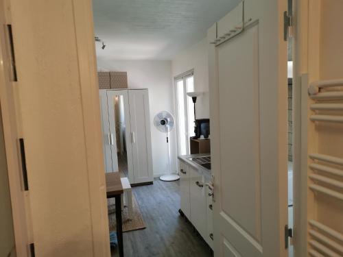 uma cozinha com armários brancos, uma mesa e uma ventoinha em lili em La Seyne-sur-Mer
