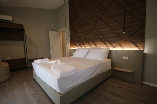 a bedroom with a bed with white sheets and pillows at Alyvia Rooms in Himare