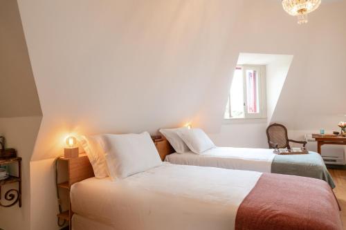 a bedroom with two beds and a chandelier at Chalet Ficalho in Cascais