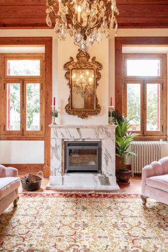 a living room with a fireplace and a chandelier at Chalet Ficalho in Cascais