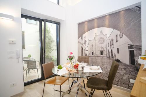 a dining room with a table and a mural of a church at Welcome Ostuni b&b in Ostuni