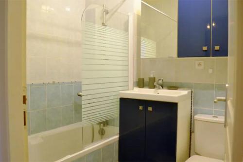 Maison St Eloi by iZiLi *Futuroscope*Jardin* في بواتييه: حمام مع حوض وحوض استحمام ومرحاض