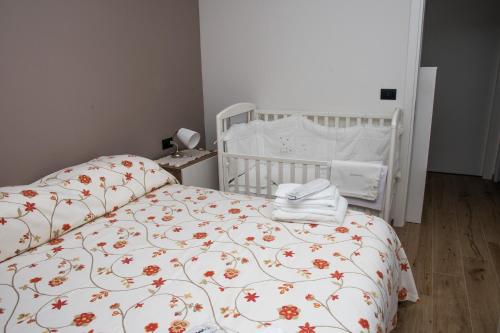 a bedroom with a white bed with a floral bedspread at Casa Valentin in Monforte dʼAlba