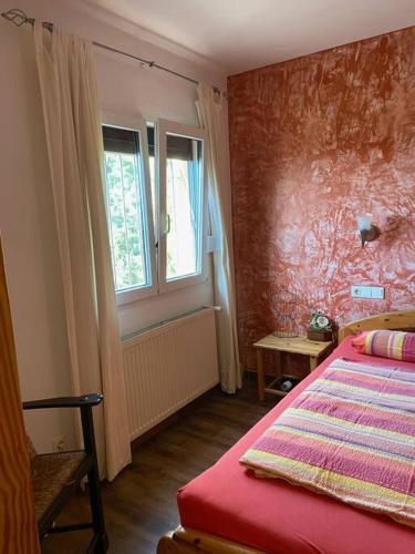 um quarto com uma cama vermelha e uma janela em The 3 Singing Palms em Lloret de Mar
