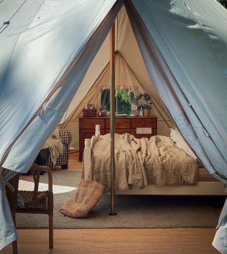 um quarto com uma cama numa tenda em Idyllisk glamping rett ved elven em Skien